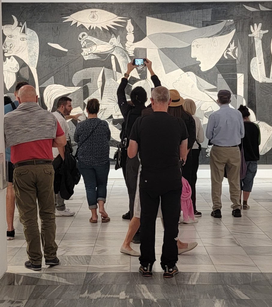 Guernica, by artist Pablo Picasso, with audience in front of the painting
