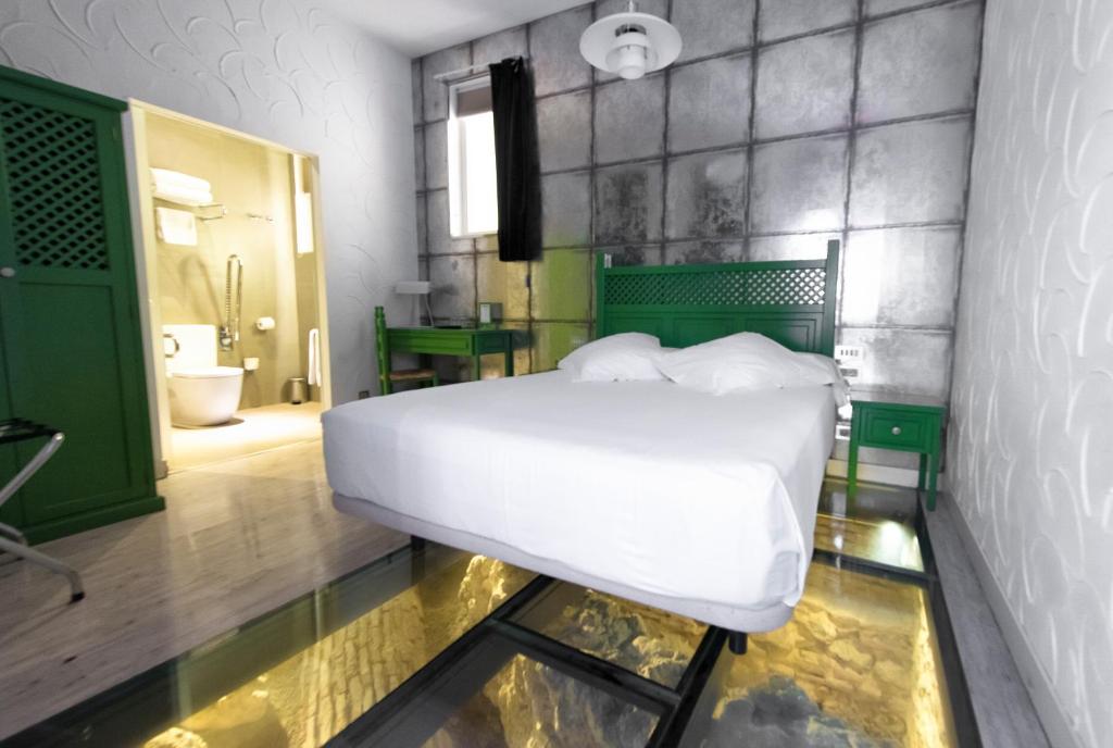 Bedroom at Posada del Dragon Boutique Hotel, with glass floor overlooking 12th century ruins.
